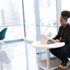 A woman sitting at a table with a laptop.