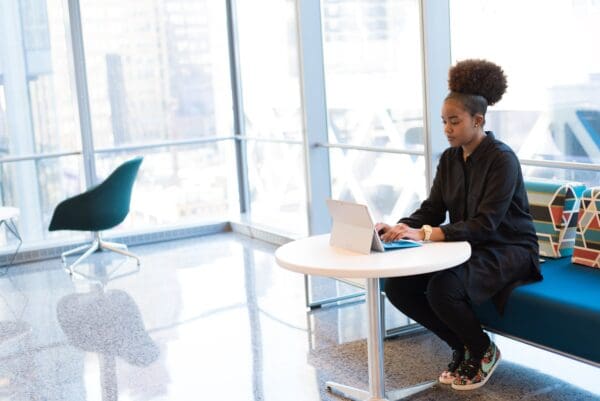 A woman sitting at a table with a laptop.