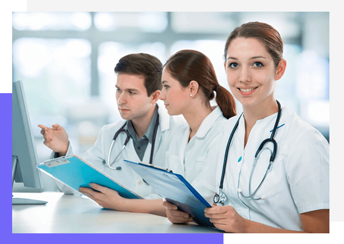 Three doctors are sitting at a table with papers.